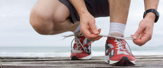 Runner tying shoelace in front of the sea
